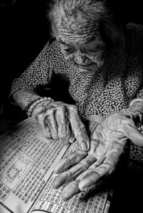 Mulher com 92 anos praticando quiromancia.